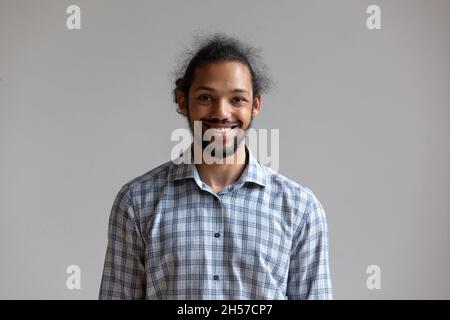 Glücklicher, tausendjähriger afroamerikanischer Mann, der von einer weißen Wand isoliert steht Stockfoto