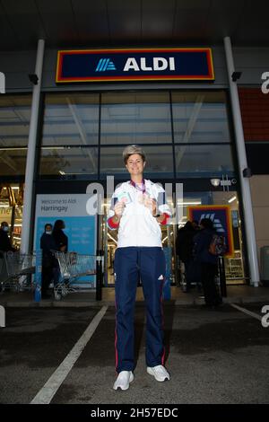 London, Großbritannien. Oktober 2021. Die britische Eishockey-Bronzemedaillengewinnerin Sally Walton posiert für ein Foto, während sie ihre Medaille vor dem neuen Aldi-Store im Norden Londons hält.im Sommer bestätigte der Budget-Supermarkt die Pläne, mehr als 450 neue Geschäfte in ganz Großbritannien, 400 in England, 30 in Wales und 20 in Schottland zu eröffnen. Schaffung von 2000 Arbeitsplätzen. Aldi ist Großbritanniens fünftgrößtes Supermarktgeschäft. Kredit: SOPA Images Limited/Alamy Live Nachrichten Stockfoto