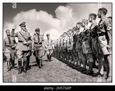 ADOLF HITLER und Reichsminister Rudolf Hess begrüssen eine uniformierte Parade der Hitlerjugend mit Hakenkreuzbändern bei einer Nürnberger Kundgebung in Nürnberg aus den 1930er Jahren Nazi-Deutschland - Stockfoto