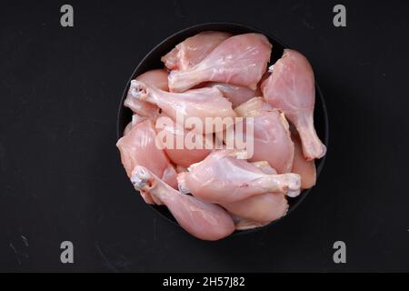 Rohes Huhn biriyani geschnitten, ohne Haut auf schwarzem Behälter angeordnet, Draufsicht. Stockfoto