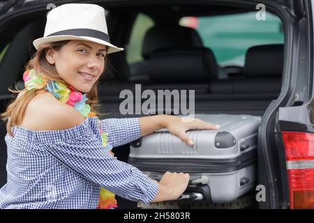 Frau, die Gepäck in einen Lastwagen passte Stockfoto