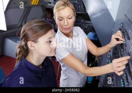 Weibliche aero Engineer, der an Helikopter im Hangar Stockfoto