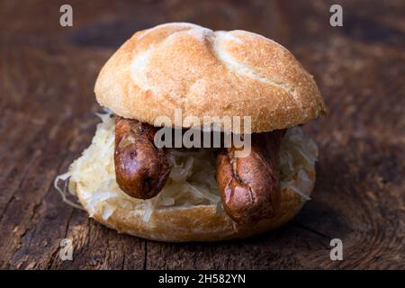 Nürnberger Würstchen mit Sauerkraut im Brötchen Stockfoto