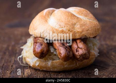 Nürnberger Würstchen mit Sauerkraut im Brötchen Stockfoto