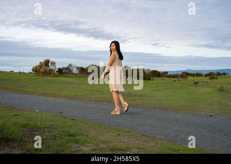 Junge asiatische Frau, die mit Gänsen läuft Stockfoto