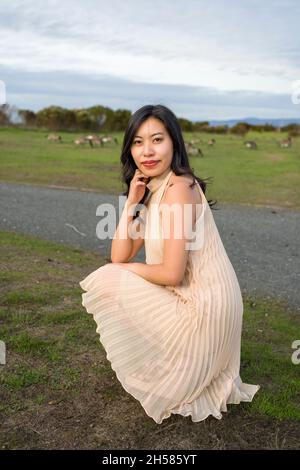 Junge asiatische Frau, die mit Gänsen läuft Stockfoto