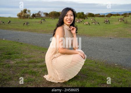 Junge asiatische Frau, die mit Gänsen läuft Stockfoto