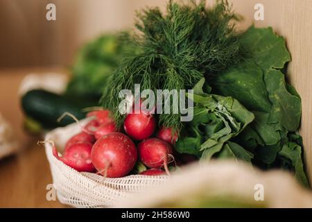 Rettich in Leinwand Lebensmittelbeutel. Gemüse in wiederverwendbaren Öko-Baumwollbeuteln auf Holztisch. Zero Waste Shopping-Konzept. Kunststoffartikel Stockfoto
