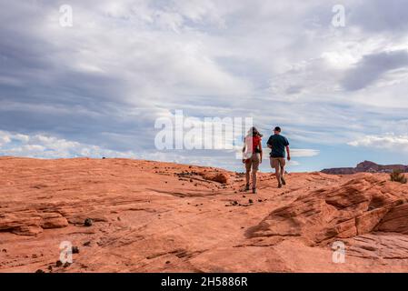 Zwei Wanderer auf der Suche nach der berühmten Feuerwelle im Valley of Fire, USA Stockfoto