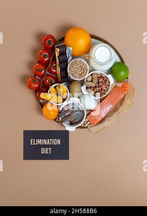 Elimination Diät-Konzept. Lebensmittelallergene auf dem Teller - Fisch, Meeresfrüchte, Milchprodukte, Erdnüsse, Nüsse, Eier, Schokolade, Weizen, Soja, Zitrusfrüchte. Stockfoto