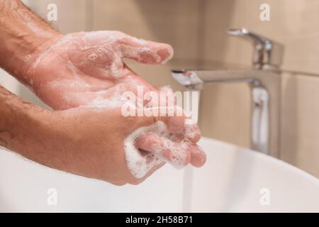 Nahaufnahme von männlichen Händewaschen mit Seife im Badezimmer, selektiver Fokus Stockfoto