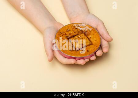 Koreanischer Dalgona Wabenzucker-Cookie mit quadratischen Formen. Hände spielen neue Trend Süßigkeiten Herausforderung Stockfoto