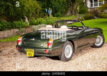 MG RV8 parkte auf ag-Schotterfahrt hinter einem steingebauten, urburbanischen Haus Stockfoto