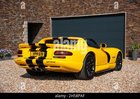 Yellow Dodge Viper SRT 10 auf einem Schotterplatz vor einem Haus und einer Garage geparkt Stockfoto