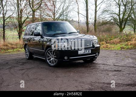 Der schwarze Range Rover parkte im Winter auf einer Waldlichtung Stockfoto