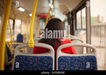 Öffentliche Verkehrsmittel. Ein Mann in einem Bus in Moskau. Das Mädchen fährt in einem regulären Bus. Details des Inneren des Verkehrs. Stockfoto