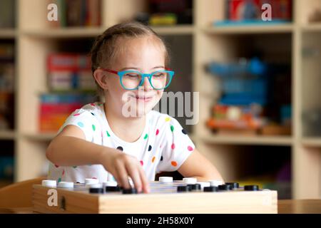 Mädchen mit Down-Syndrom spielt mit ihrer Schwester in Quarantäne Checkers Stockfoto