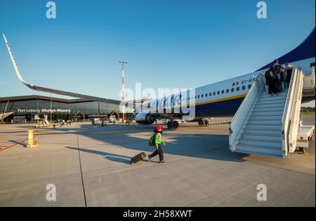 13/09/2021. Flughafen Olsztyn-Mazury, Polen. Passagiere mit Koffern auf der Asphaltbahn des Flughafens fahren zum Flugzeug, um an Bord zu gehen. Flugzeug bereit zum Abflug. Stockfoto