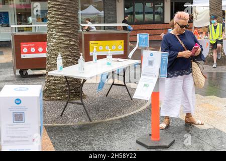 Frau, die ihr Mobiltelefon benutzt, um mit QR-Code auf dem Manly Beach Farmers Market in Sydney, Australien, einzuchecken Stockfoto