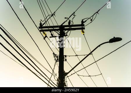 Strom- und Telefonkabel und Drähte auf einem Mast in den Straßen der Metropole. Salvador, Bahia, Brasilien. Stockfoto