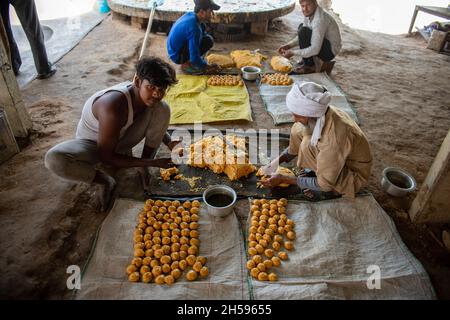 Roorkee, Indien. November 2021. In einer saisonalen Einheit der Jaggery-Produktion im unteren Teil von Roorkee bereiten die Arbeiter jaggery-Rundkugeln zum Verkauf vor.die Herstellung von Jaggery aus Zuckerrohrsaft ist in vielen Teilen Indiens eine traditionelle ländliche Industrie. Mehr als 70 % der weltweiten Produktion von Jaggery werden von Indien produziert. Kredit: SOPA Images Limited/Alamy Live Nachrichten Stockfoto