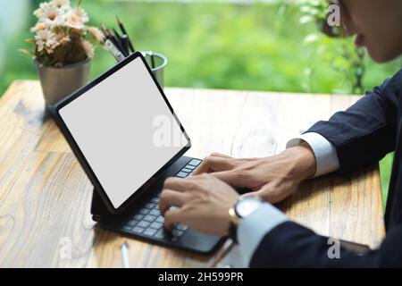 Nahaufnahme Junge Geschäftsmann in einem formellen Anzug mit digitalen Tablet. Tablet leeren Bildschirm mockup. Stockfoto