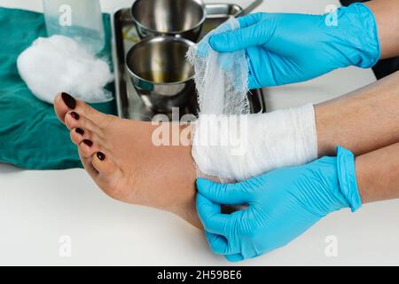 Nahaufnahme Arzt verband das Bein des Patienten nach der Wundreinigung Stockfoto