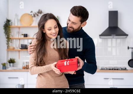 Liebevoller Ehemann überraschend charmante Frau mit Geschenk-Geschenkbox am romantischen Tag Stockfoto