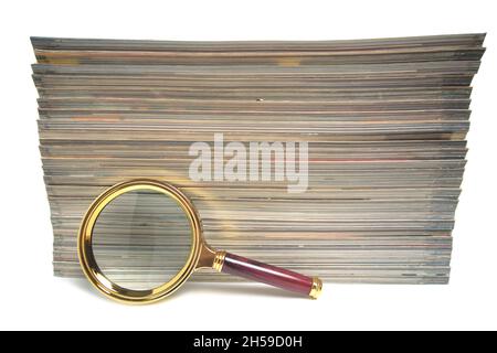 Stapel von Zeitschriften und Lupe auf weißem Hintergrund.Konzept des Lernens und der Verfolgung von Wissen Stockfoto