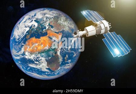 Forschungssatellit mit offenen Sonnenkollektoren in der geostationären Umlaufbahn der Erde. Elemente dieses Bildes, die von der NASA eingerichtet wurden Stockfoto