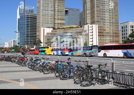 Bunte Busse und Fahrräder Reihen sich entlang einer belebten Straße in Jamsil, Seoul, an Stockfoto