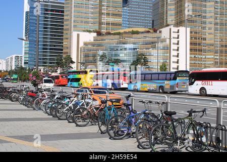 Bunte Busse und Fahrräder Reihen sich entlang einer belebten Straße in Jamsil, Seoul, an Stockfoto