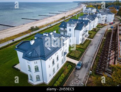 Heiligendamm, Deutschland. Oktober 2021. Die Häuser der sogenannten Perlenkette am Ostseestrand von Heiligendamm und die Kolonnaden werden saniert. (Luftaufnahme mit Drohne) die Perlenkette besteht aus sieben Strandvillen entlang der Küste östlich des Grand Hotels. Jahrzehntelang waren die historischen Villen und Behausungshäuser, die Mitte des 19. Jahrhunderts erbaut wurden, unbewohnt und verfielen. (To dpa 'Heiligendamm: Fünfte Villa der Perlenschnur wird bald komplett restauriert') Quelle: Jens Büttner/dpa-Zentralbild/dpa/Alamy Live News Stockfoto