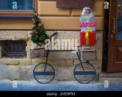 Weihnachten dekoratives Fahrrad mit vielen Geschenkboxen und verzierten Tannenbäumen Stockfoto