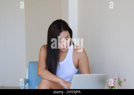 New Normal, eine Geschäftsfrau, die Computer verwendet, um für ein Unternehmen über das Internet auf Ihrem Schreibtisch zu Hause zu arbeiten. Stockfoto