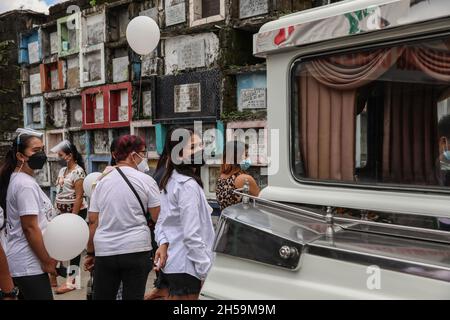 Die Menschen besuchen eine Beerdigungszeremonie, während andere ihre verstorbenen Angehörigen zur Feier des All Souls’ Day in einem öffentlichen Friedhof besuchen. Quezon City, Metro Manila, Philippinen. Stockfoto