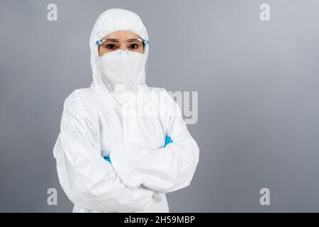Ärztin mit gekreuzten Armen, mit PSA-Anzug gegen eine Coronavirus(covid-19)-Pandemie Stockfoto