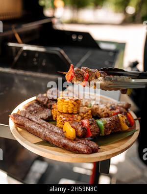 Gegrilltes Gericht mit Würstchen, Fleisch und Maisgrill Stockfoto