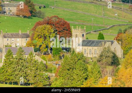 Langthwaite, Archengarthdale, England, November 2 2021. St. Mary's Church im Herbst mit bunten Bäumen und Vieh auf den Feldern. Yorkshire Dales Stockfoto