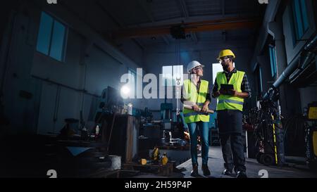 Porträt von Industrieinspektoren mit Tablet, die eine allgemeine Überprüfung durchführen und in der Metallwerkstatt sprechen Stockfoto