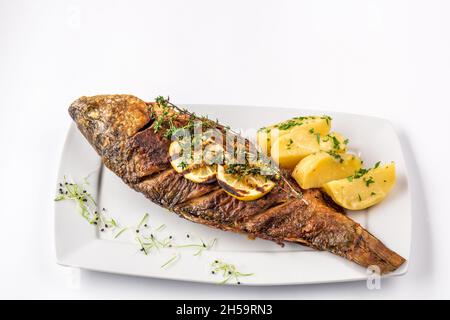 Gegrillter Karpfen mit Rosmarinkartoffeln und Zitrone, Nahaufnahme Stockfoto