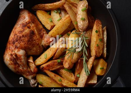 Gebackene Hühnerschenkel Viertel und Schlagstock gewürzt mit Knoblauch und Kräutern mit Kartoffeln in einer Auflaufform Stockfoto