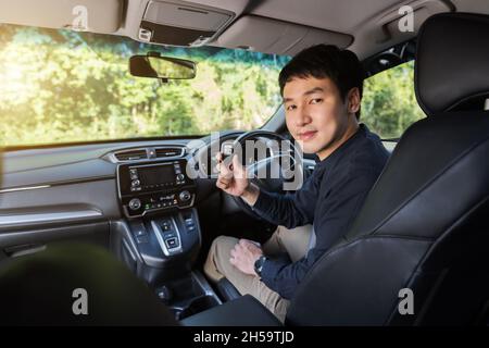 Junger Mann mit intelligenter Schlüsselfernbedienung in einem Auto Stockfoto