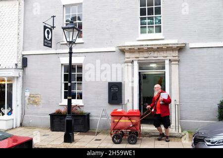 Königlicher Postbote mit weißem Bart, der Briefe mit rotem Postwagen außerhalb des Hauses Rye East Sussex England im Herbst 2021 LIEFERTE KATHY DEWITT Stockfoto