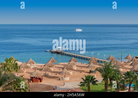 Sonniger Strand in tropischem Resort Stockfoto