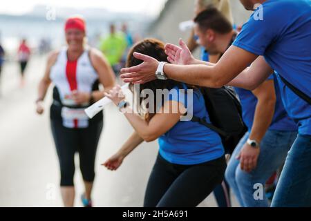 Eine Fangruppe jubelt einem Marathonläufer an Stockfoto