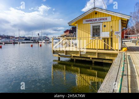 Stockholm, Schweden - 8. April 2021: Hafenbüro in gelbem Holz am Wasser Stockfoto