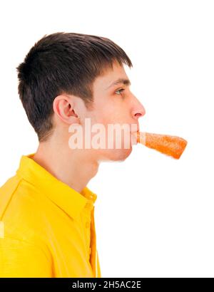 Junger Mann mit einer Karotte im Mund isoliert auf dem weißen Hintergrund Stockfoto