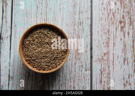 Ganze Fenchelsamen, Fenchel, Fenchel, Fenchel aus Florenz, Fenchel oder Hauptfenchel (Foeniculum vulgare Mill) in einer Holzschale. Auf einem alten Holztisch. Stockfoto