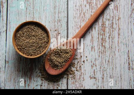 Samen von ganz Fenchel, Fenchel, Fenchel, Florentiner Fenchel, Flunder oder Kopffenchel (Foeniculum vulgare Mill) in einer Schüssel und einem Holzlöffel. Auf einem alten Tisch. Stockfoto